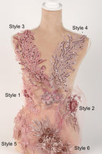 A mannequin with various pink and pink floral and sequin designs on its body, including a large floral piece and smaller floral pieces.