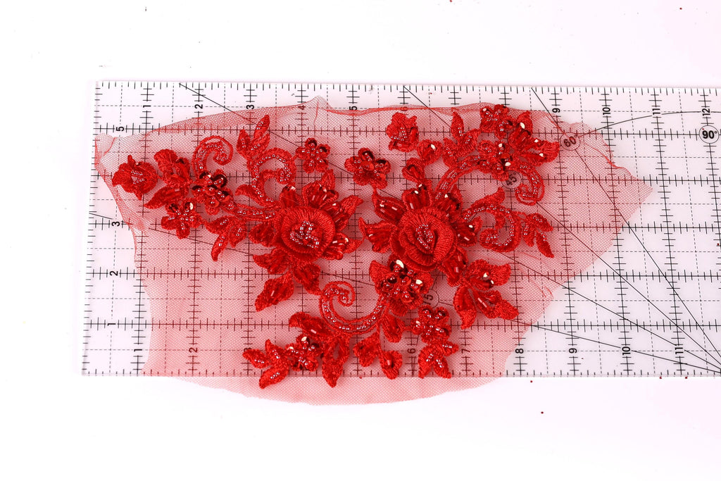 a close-up view of a red floral lace piece, with intricate details and a vibrant red color.