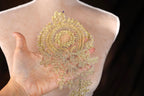 a woman's hand holding a piece of gold sequins