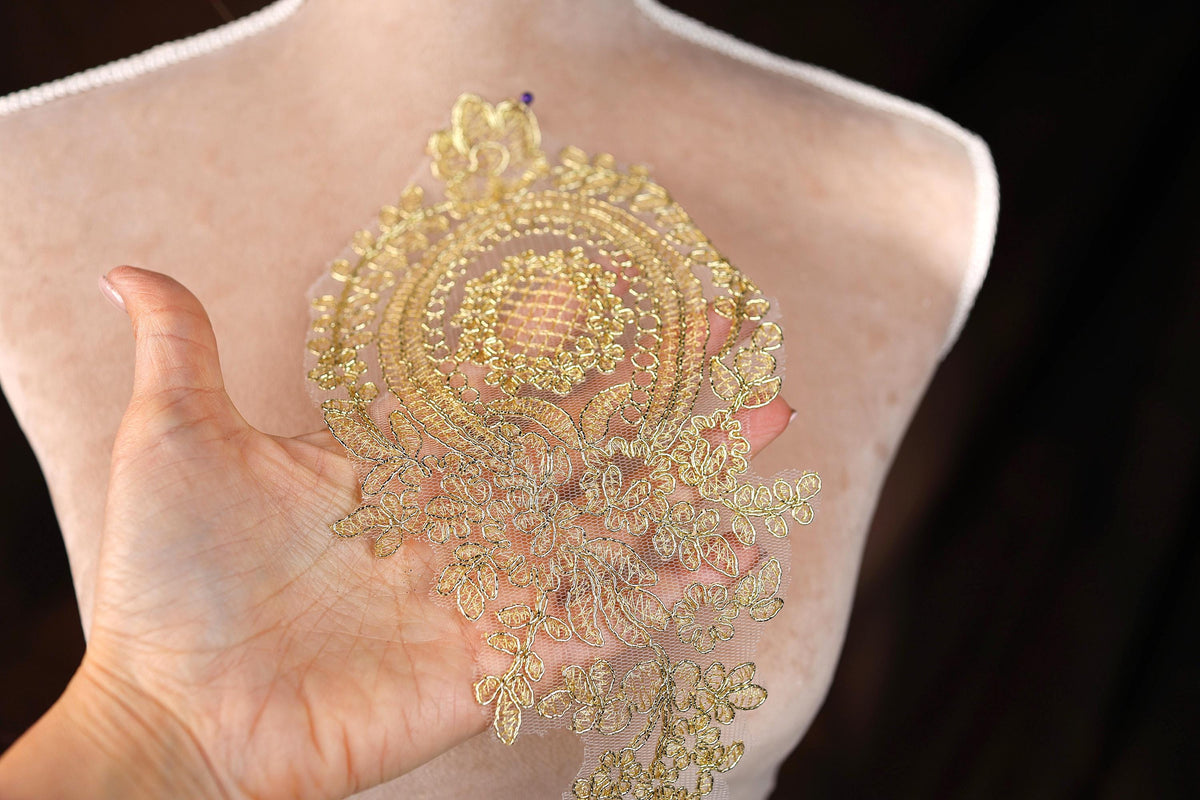 a woman's hand holding a piece of gold sequins