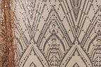 a close-up view of a fabric with a repeating pattern of black and gold sequin designs. The pattern consists of diagonal lines and shapes, creating a visually striking and intricate design. The fabric appears to be a light-colored material, possibly beige or off-white, with the black and gold sequins adding a touch of sparkle and glamour.