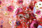 a close-up view of a vibrant red fabric adorned with a variety of colorful flowers, including pink, purple, and yellow flowers, creating a visually striking and intricate design.