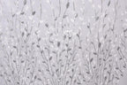 a repeating pattern of silver and white leaf-like designs on a light gray background.