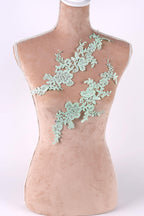 A mannequin torso with a floral lace design on the back.