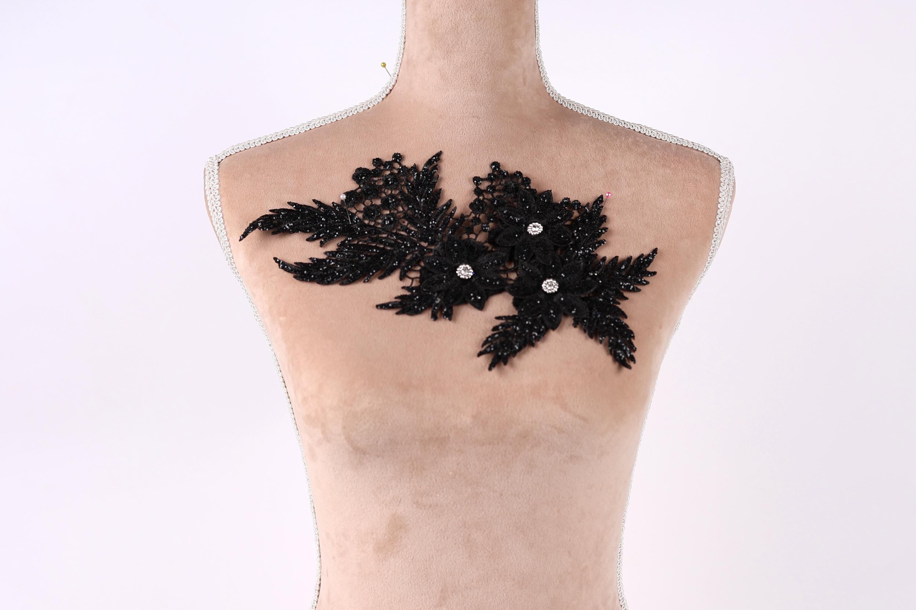 A mannequin with a decorative black lace piece on its chest.