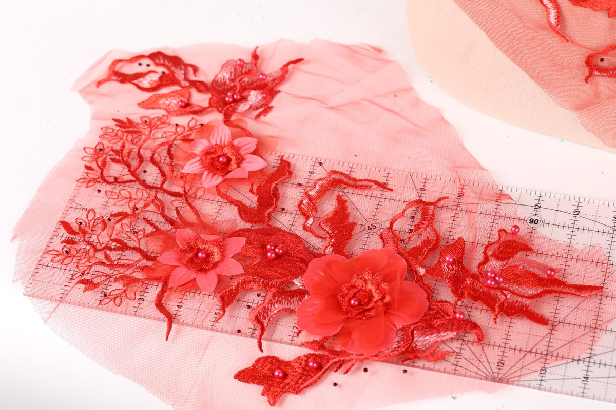 a close-up view of a red floral design on a transparent surface, with a ruler visible in the background.
