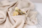 A close-up view of a fabric with a floral arrangement of yellow flowers resting on it.
