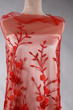 A red dress with a floral pattern on the front, featuring red flowers and leaves.