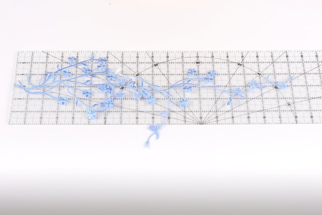 a clear ruler with blue flower-like designs placed on it.