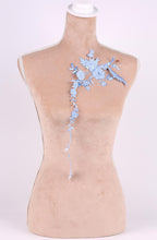A mannequin with a floral embroidered patch on its shoulder.