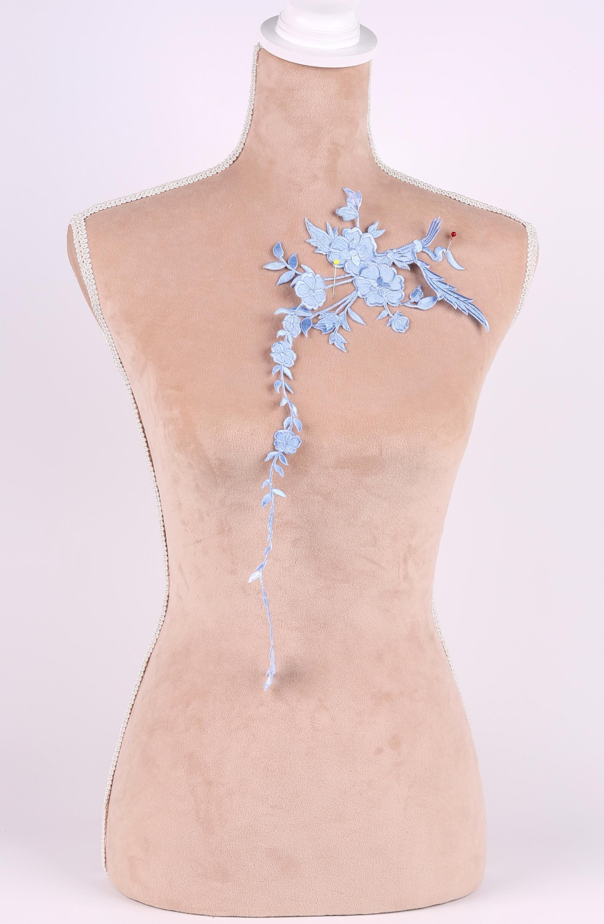 A mannequin with a floral embroidered patch on its shoulder.