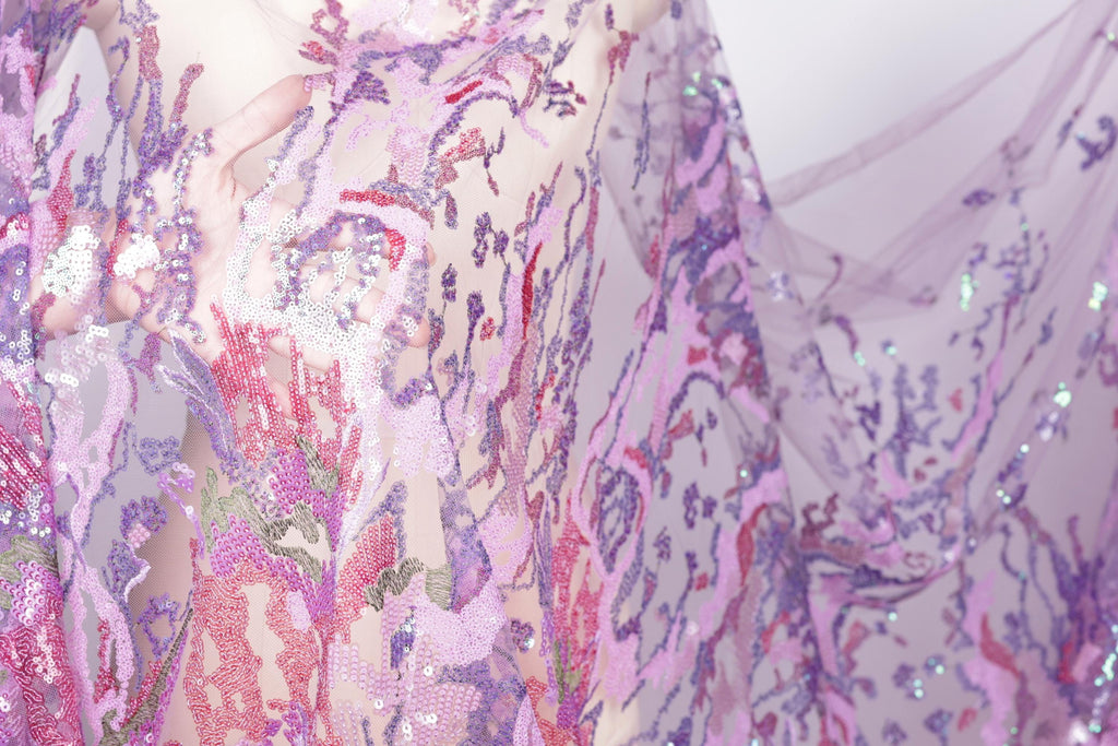 a close-up view of a fabric with a vibrant, multicolored pattern of sequins and threads, creating a visually striking and intricate design.