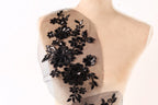 A mannequin torso with a black floral embroidered patch on the left side.