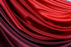 The image is a close-up of a fabric with a gradient of red and purple colors, creating a visually striking and textured appearance.