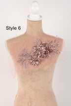 A mannequin wearing a pink floral embroidered patch on its shoulder.