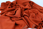 a close-up view of a crumpled, orange fabric with a textured appearance.