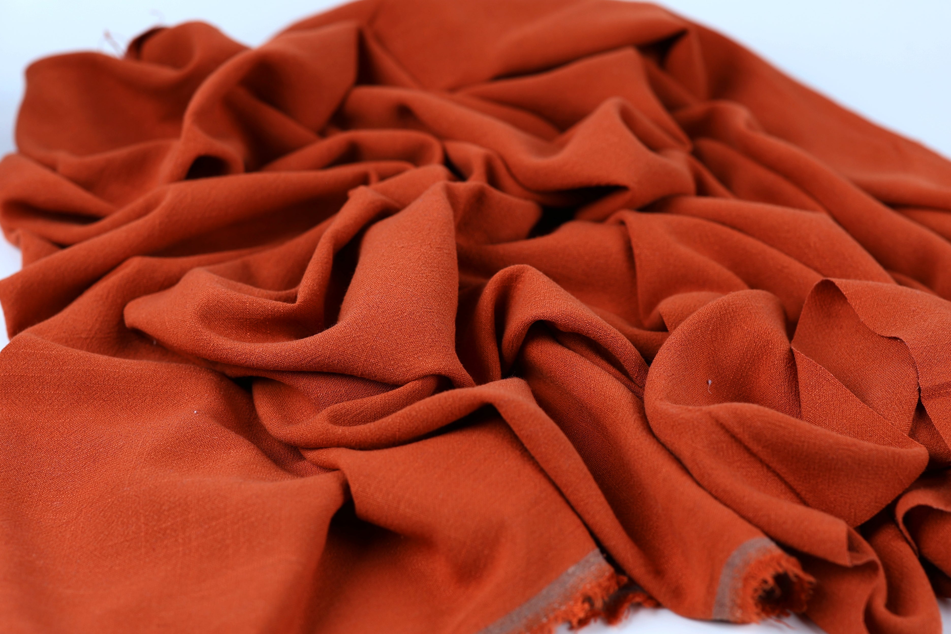 a close-up view of a crumpled, orange fabric with a textured appearance.