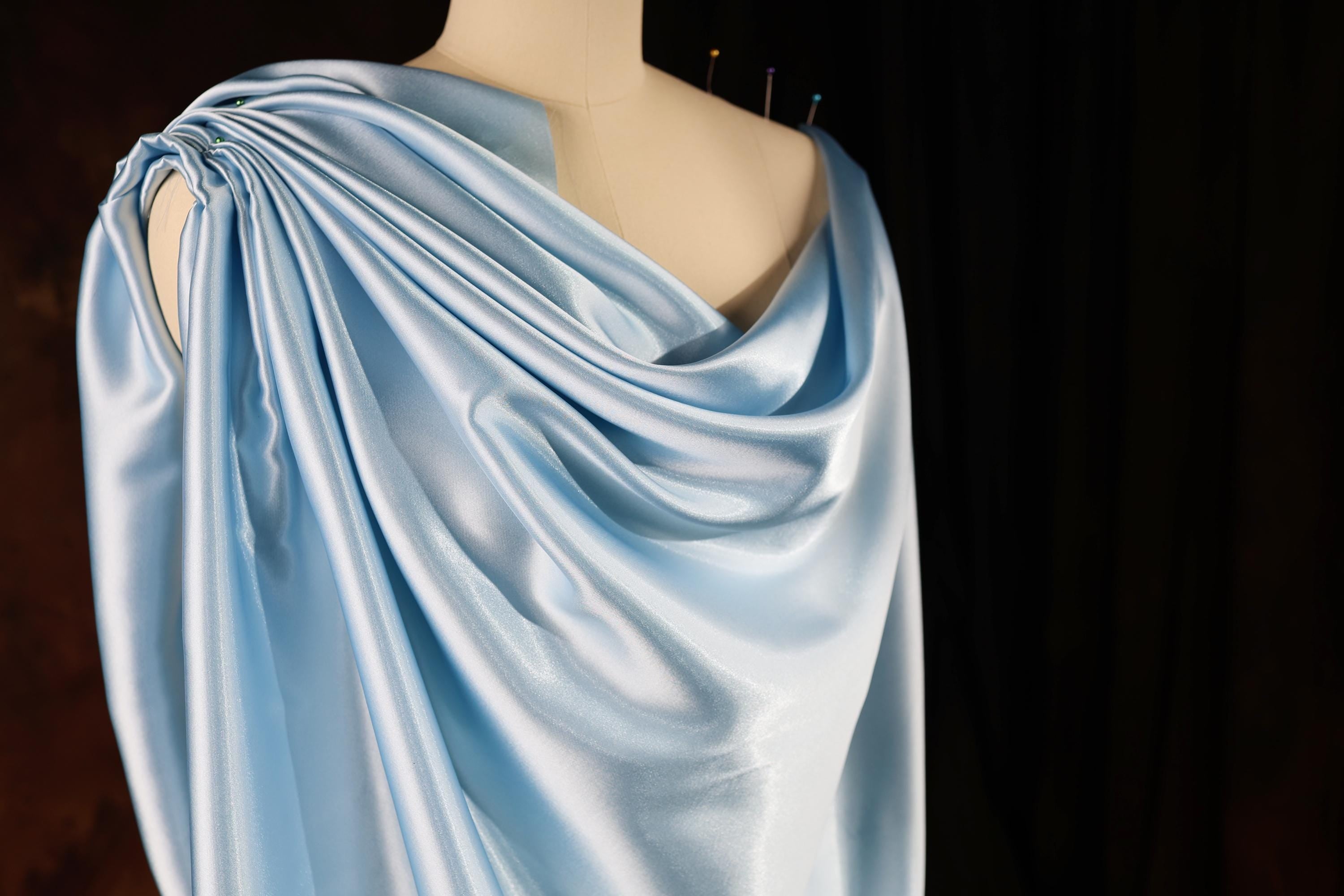 a mannequin wearing a blue draped dress
