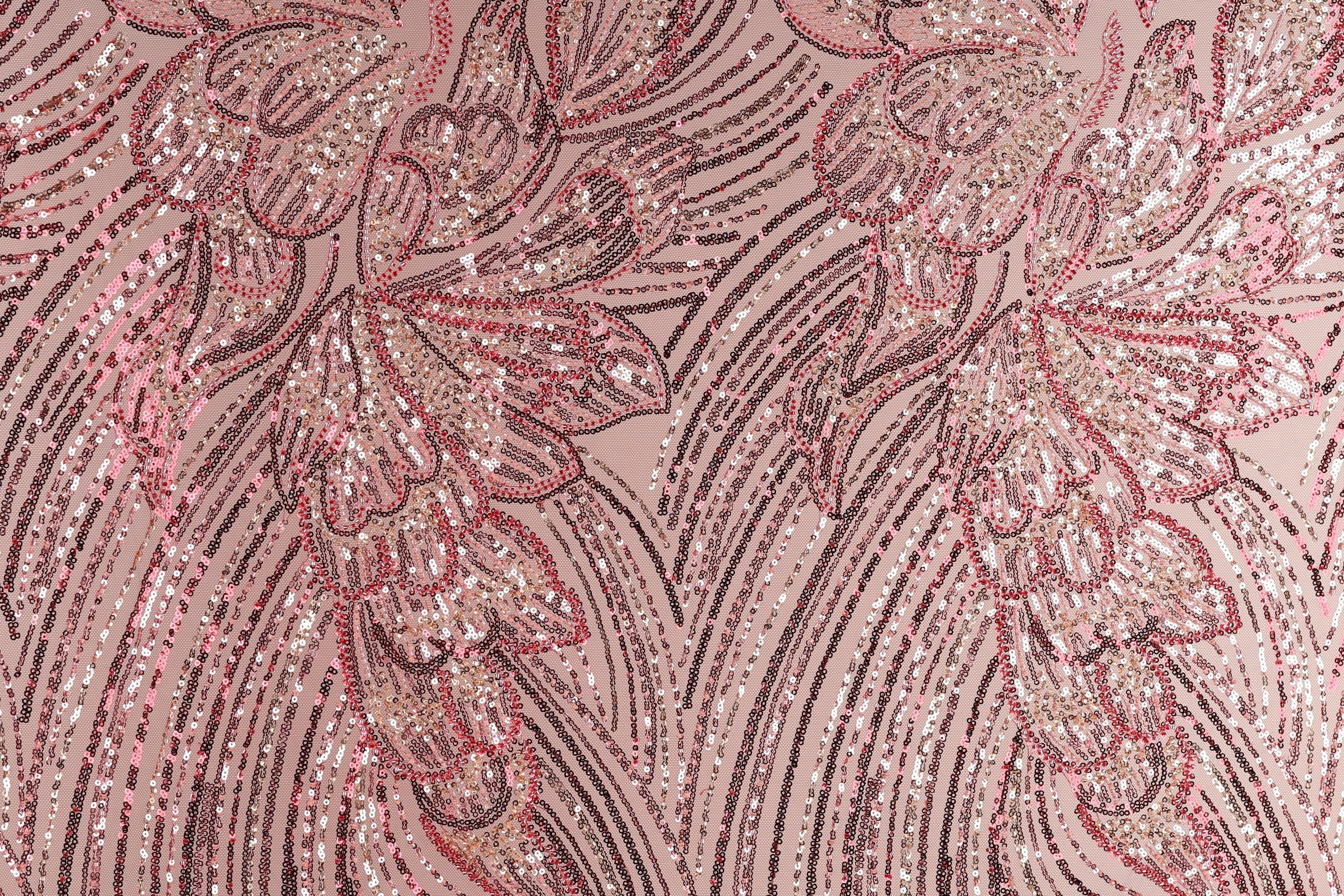 a close-up view of a fabric with a pink and red floral pattern, composed of numerous small sequins or beads arranged in a repeating, intricate design.