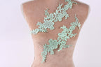 a mannequin torso with a decorative green lace overlay on it.