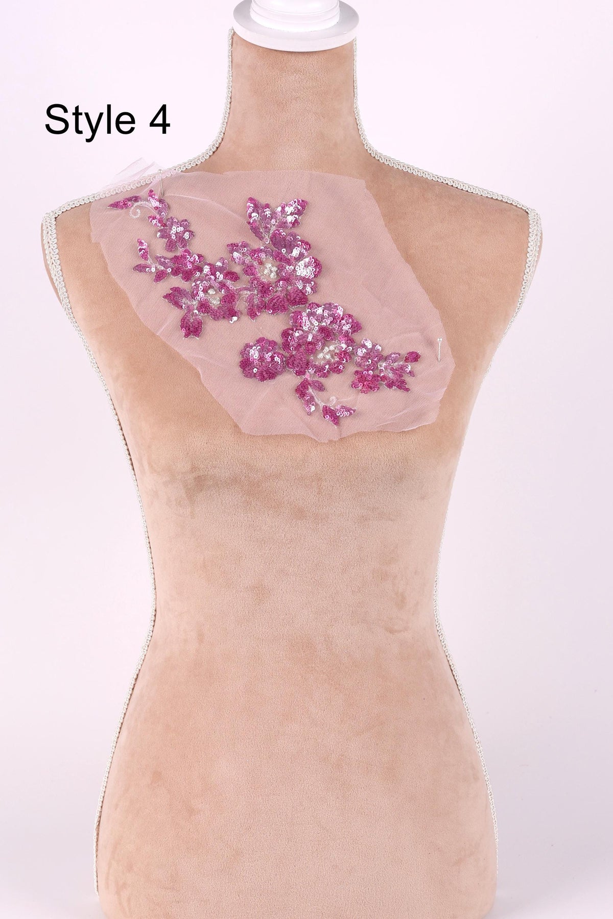 A mannequin with a pink floral embroidered patch on its chest.