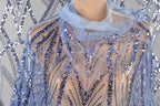 A close-up view of a person wearing a blue sequined dress with a sheer overlay.