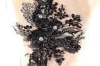 a close-up view of a delicate, intricate black lace piece adorned with sequins and flowers.