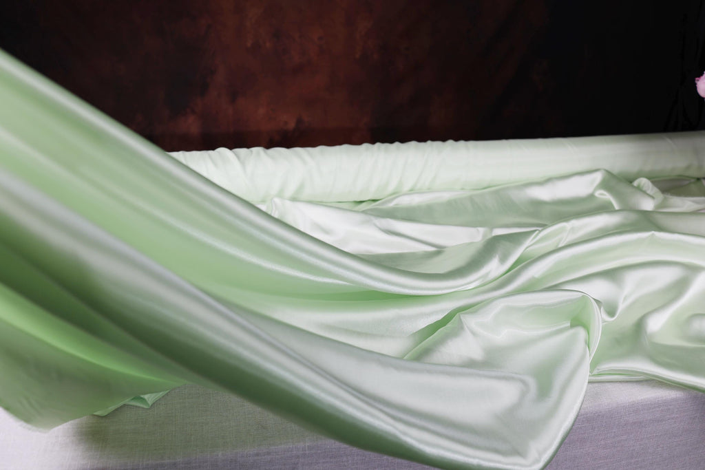 a bed with a white sheet and a pink flower