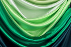 a close-up view of a fabric with a gradient of green and blue colors, creating a visually appealing and textured appearance.