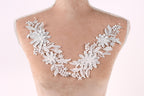 A mannequin torso with a decorative lace overlay featuring white flowers and leaves.