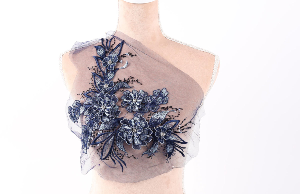A mannequin wearing a dress with a floral pattern on the shoulder area.
