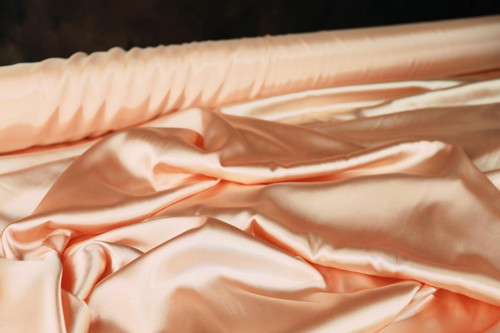 a close up of a bed with a pink comforter