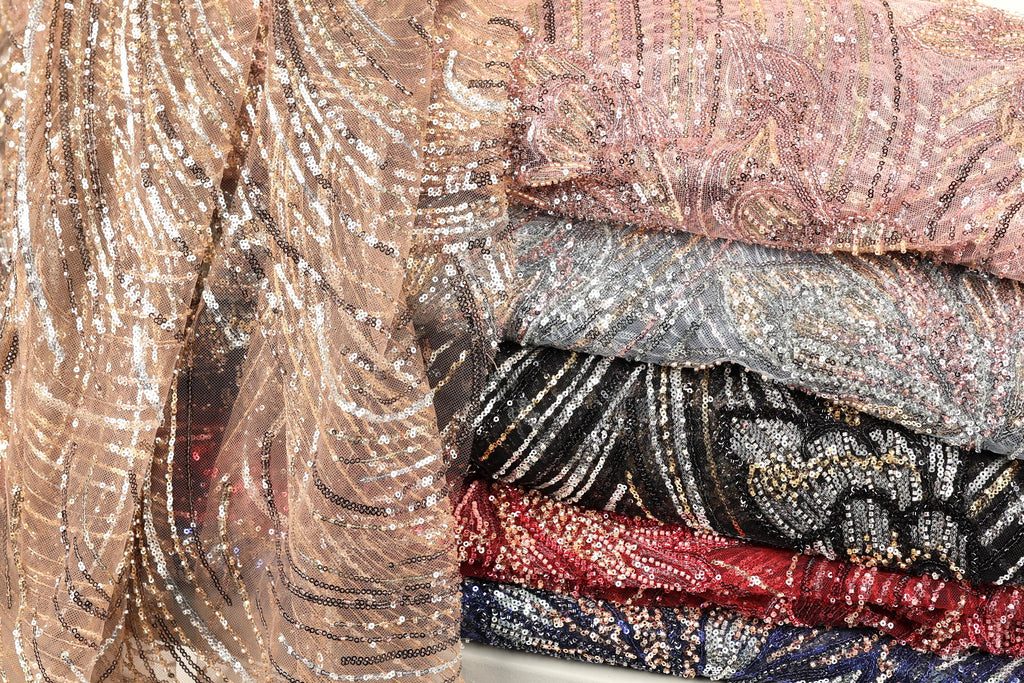 a variety of colorful, sequined fabrics stacked together, showcasing a range of patterns and textures.