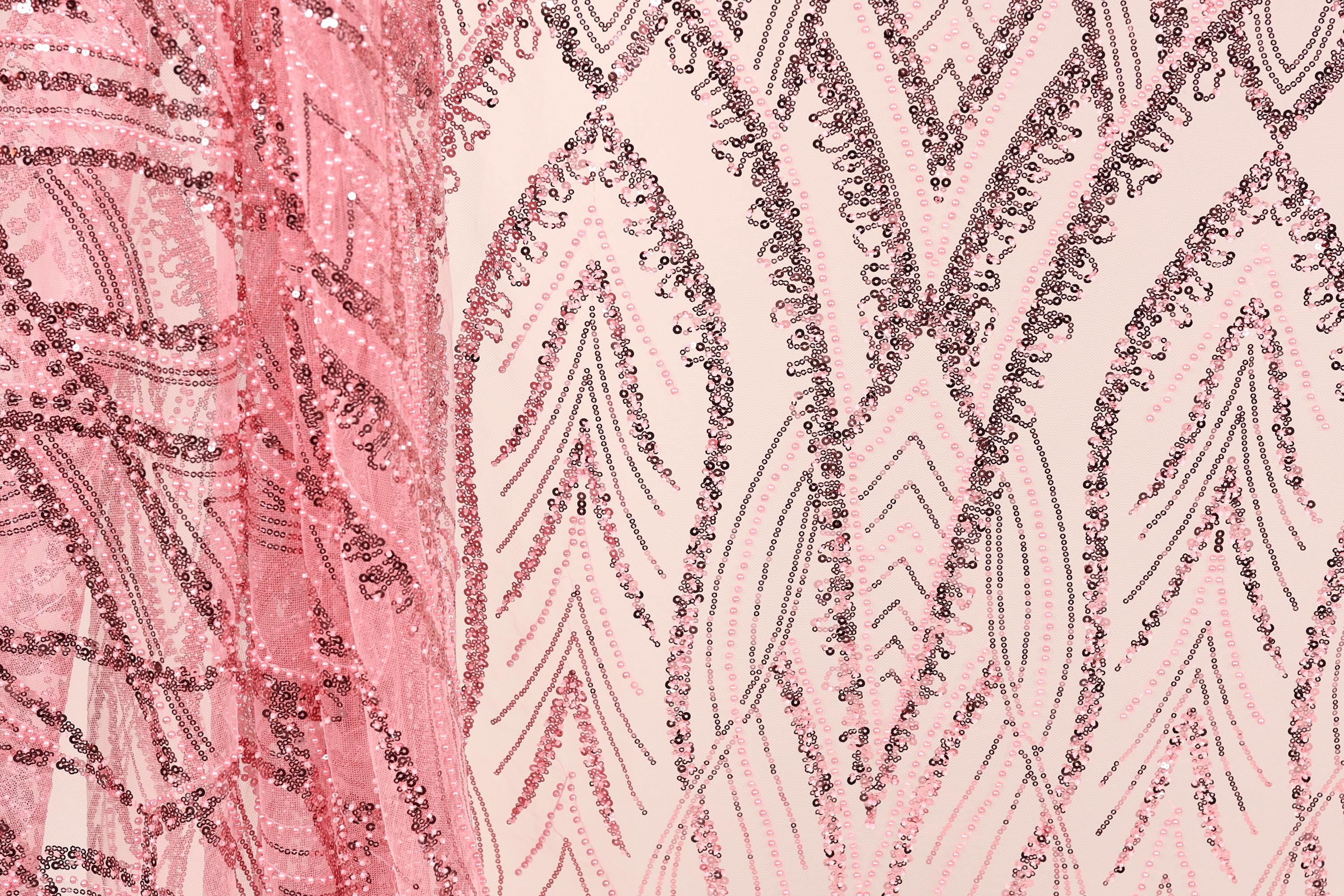 a close-up view of a fabric with a pink and black sequin pattern. The fabric appears to be a sheer material, with a repeating pattern of sequin shapes in shades of pink and black. The pattern is intricate and detailed, with the sequins arranged in a way that creates a visually striking and textured appearance.