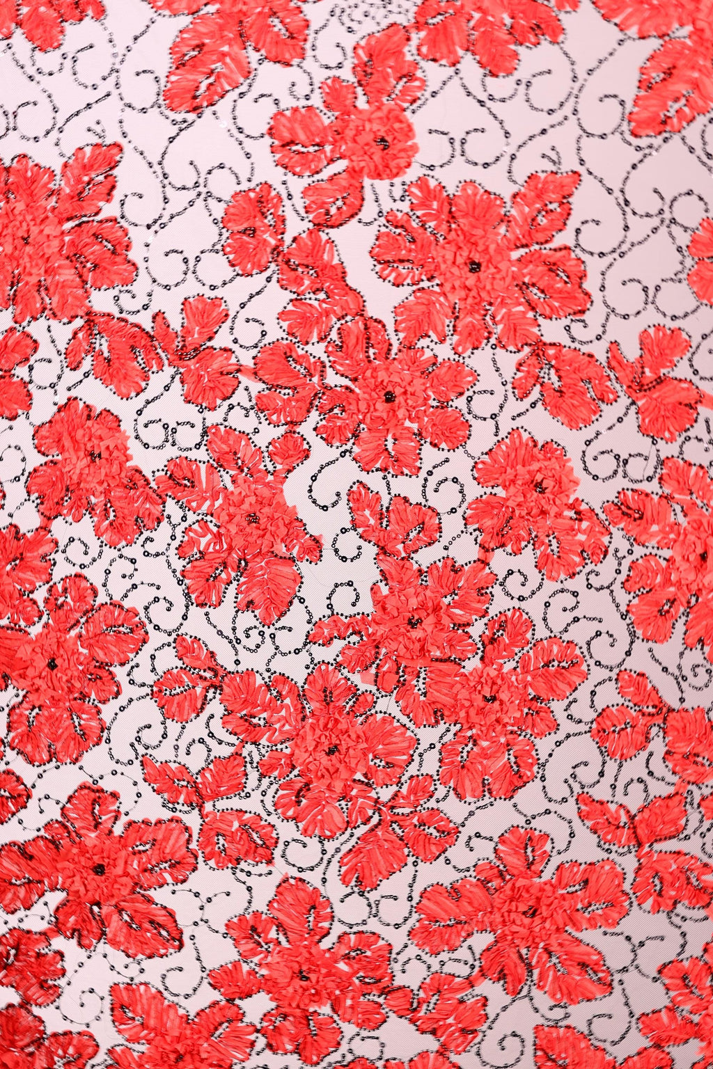 a close-up view of a fabric with a repeating pattern of red flowers and leaves. The flowers are the main focus of the image, with their vibrant red color and intricate details creating a visually striking pattern. The leaves, which are also red, are scattered throughout the fabric, adding to the overall floral design. The image does not contain any text or other discernible objects, and the focus is solely on the floral pattern.