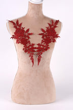 A mannequin wearing a red floral embroidered shoulder piece.