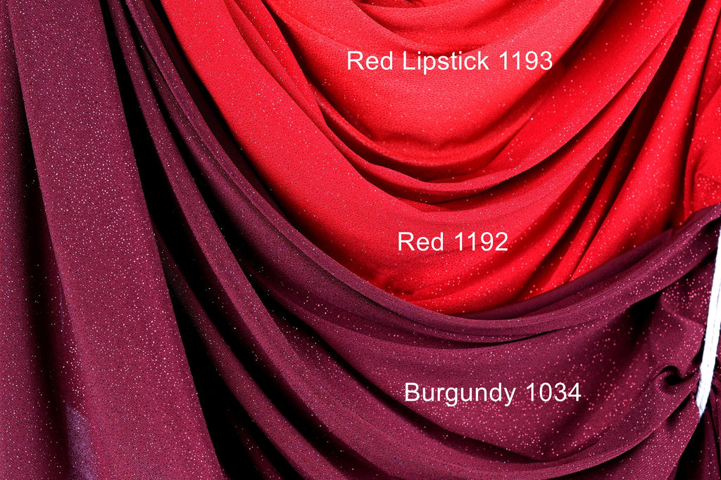 a close-up view of a fabric with a red and burgundy color scheme. The fabric appears to be a sheer material, with a red color dominating the top portion of the image. The burgundy color is visible in the bottom portion of the image. The fabric is described as having a glittery texture, which adds a sparkly effect to the overall appearance.