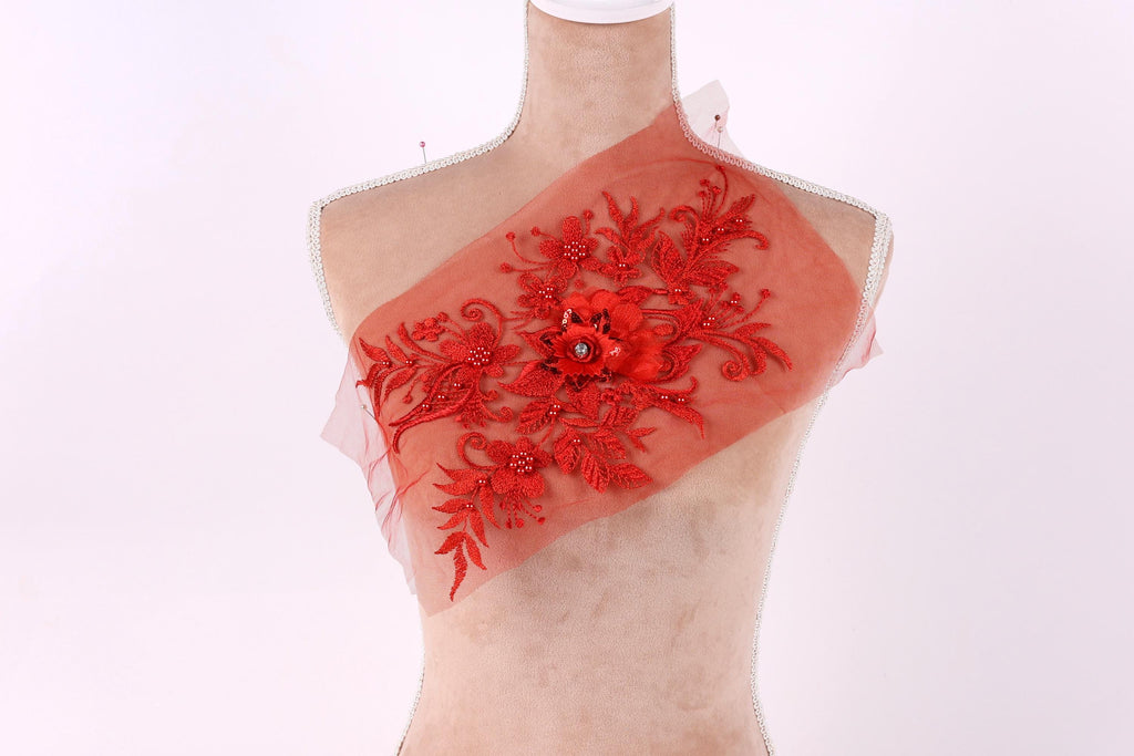 A mannequin with a red floral embroidered patch on its chest.