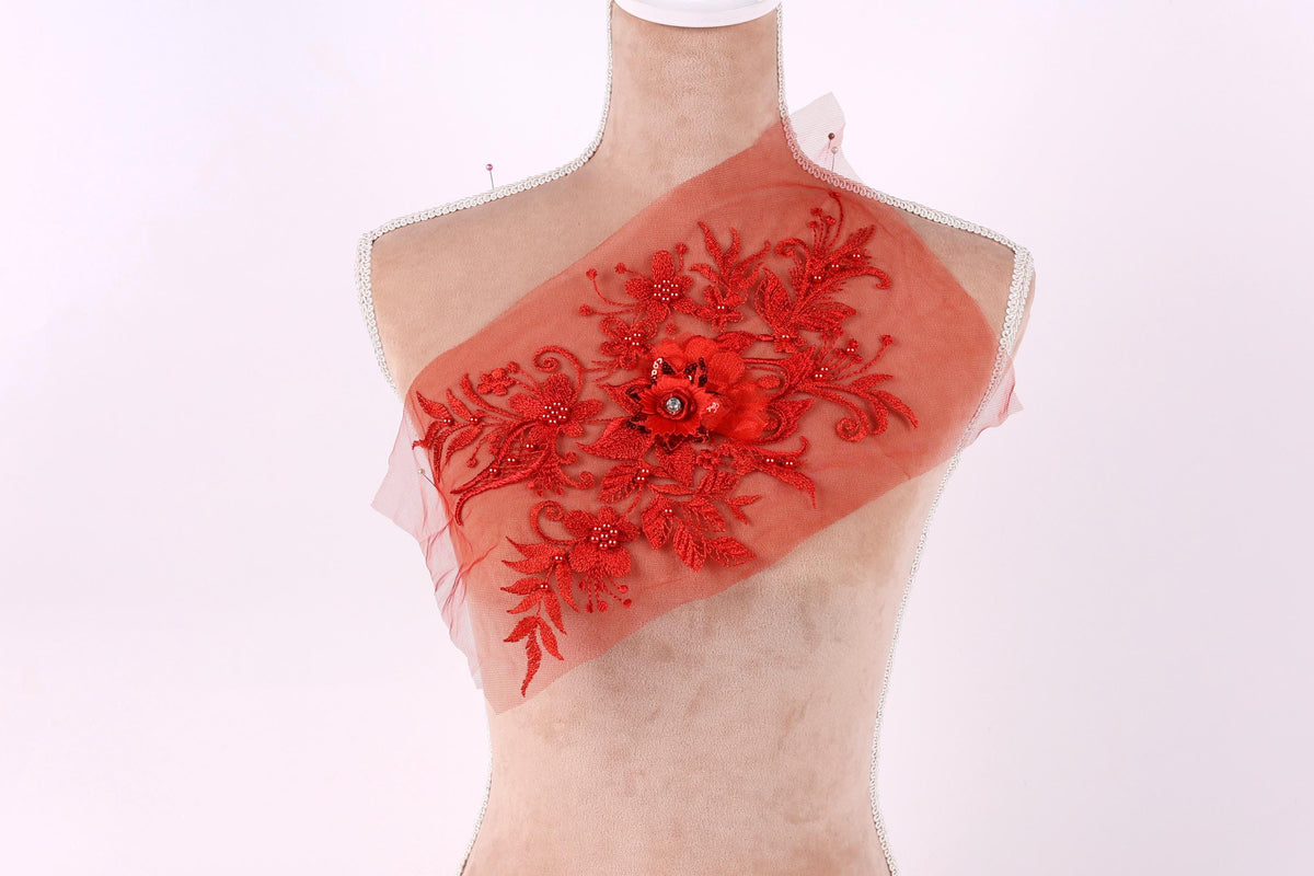A mannequin with a red floral embroidered patch on its chest.