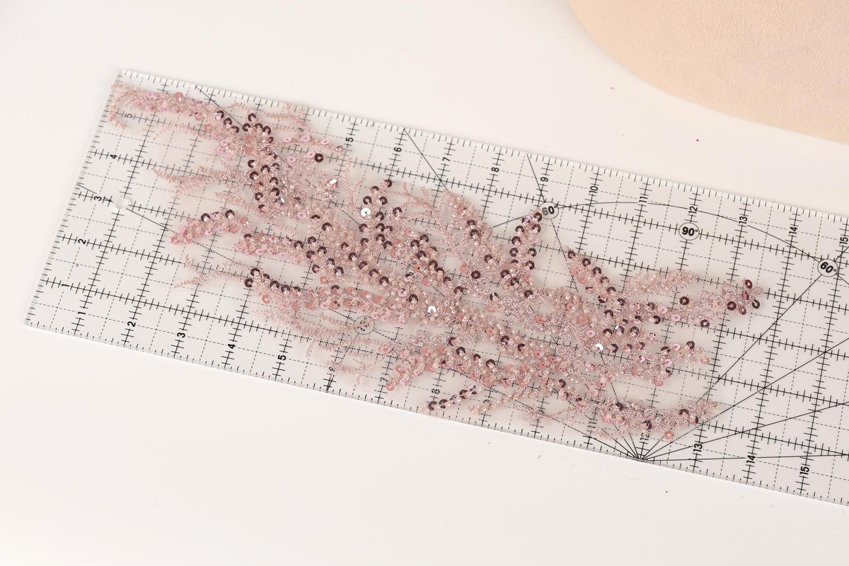 a clear ruler with a pink and purple floral pattern or design on it, placed on a white surface.
