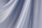 a close-up view of a blue fabric, possibly a piece of clothing or a textile. The fabric appears to be wrinkled and has a smooth texture, suggesting it might be made of a soft, flowing material.
