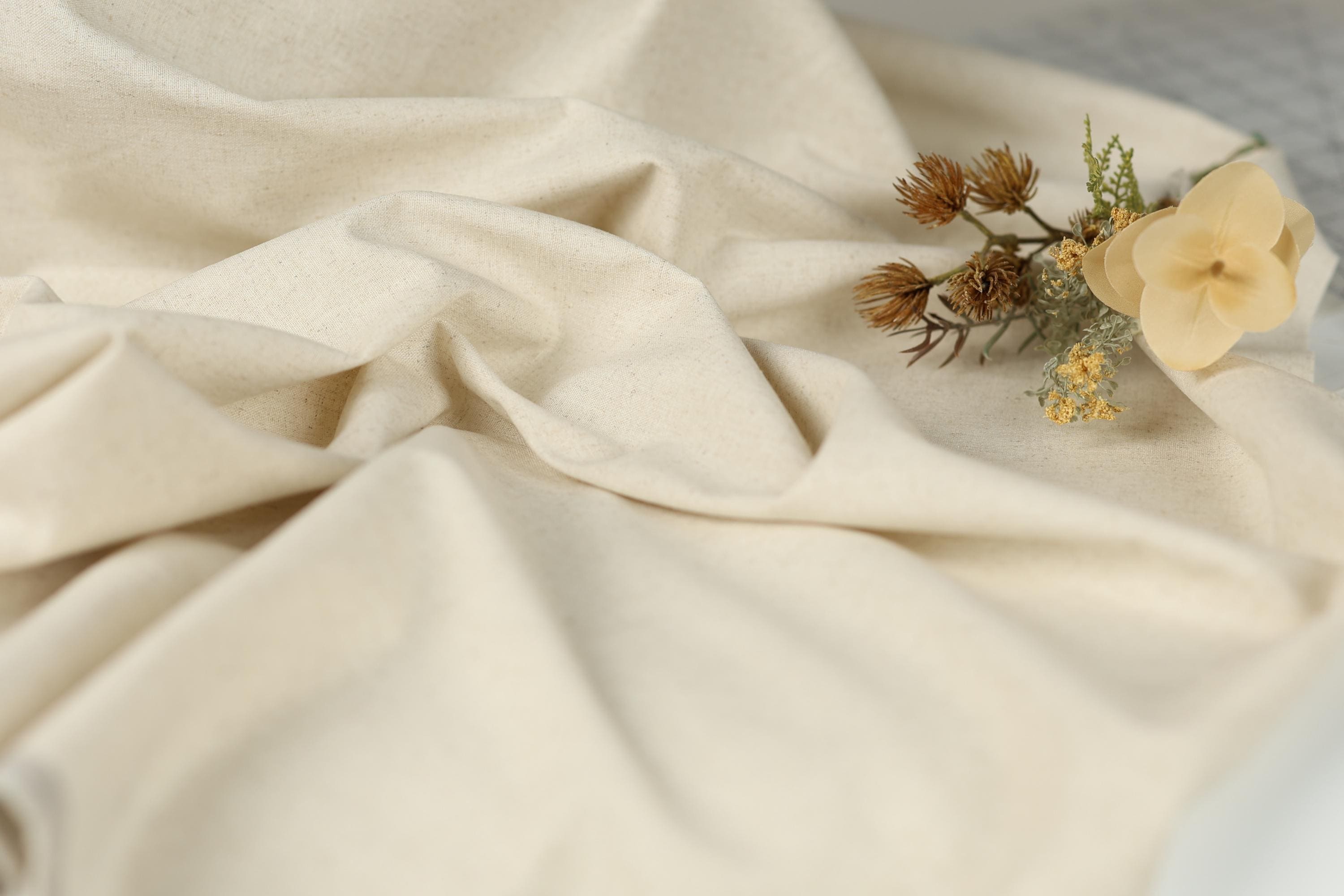 a close-up view of a white fabric with a delicate flower arrangement resting on top of it.