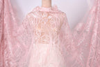 A mannequin wearing a pink lace dress with a floral pattern.