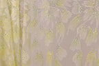 a close-up view of a fabric with a floral pattern, including yellow and white flowers with sparkles. The fabric appears to be a sheer material, possibly a sheer dress or garment.