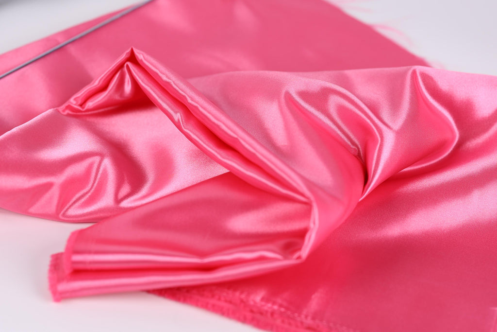 A close-up image of a shiny, pink satin fabric.