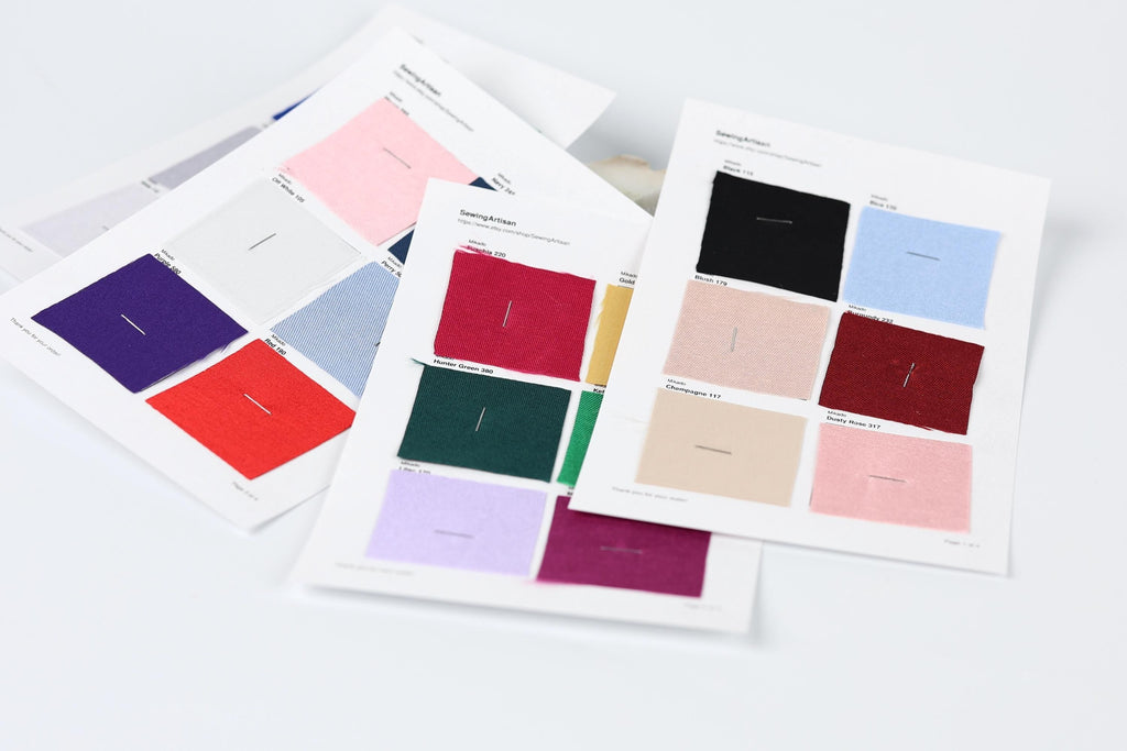 a collection of fabric swatches or color samples, each with a label indicating the color and possibly a description or brand name.