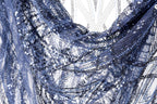 The image is a close-up of a fabric with a blue and silver sequin pattern, featuring a delicate and intricate design.
