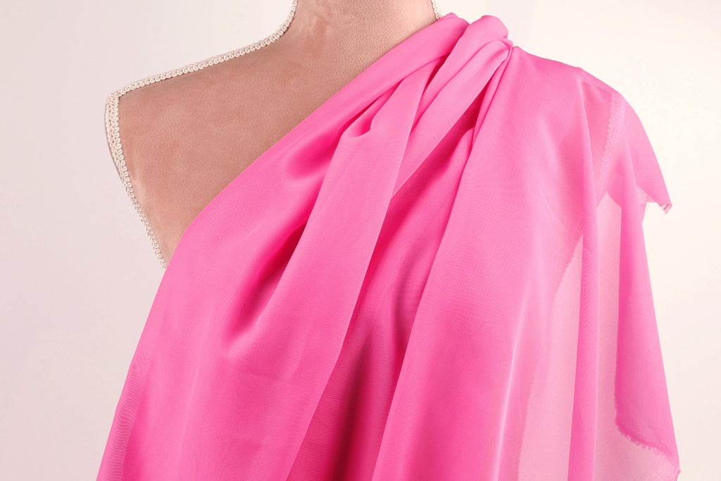 A mannequin wearing a bright pink one-shoulder dress.