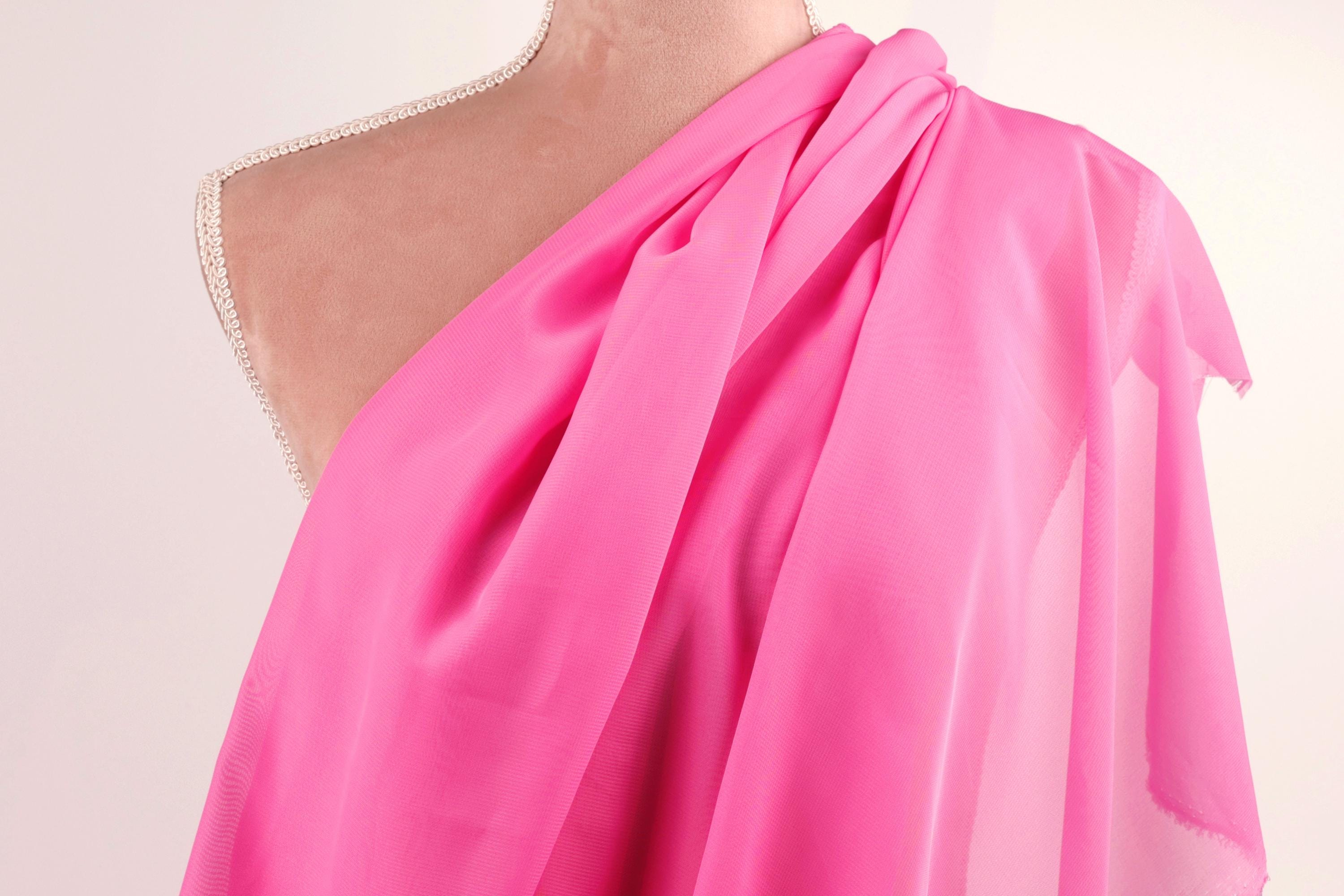 A mannequin wearing a bright pink one-shoulder dress.
