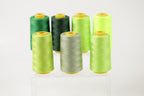 a collection of six spools of thread in various colors, including green, black, and lime green.
